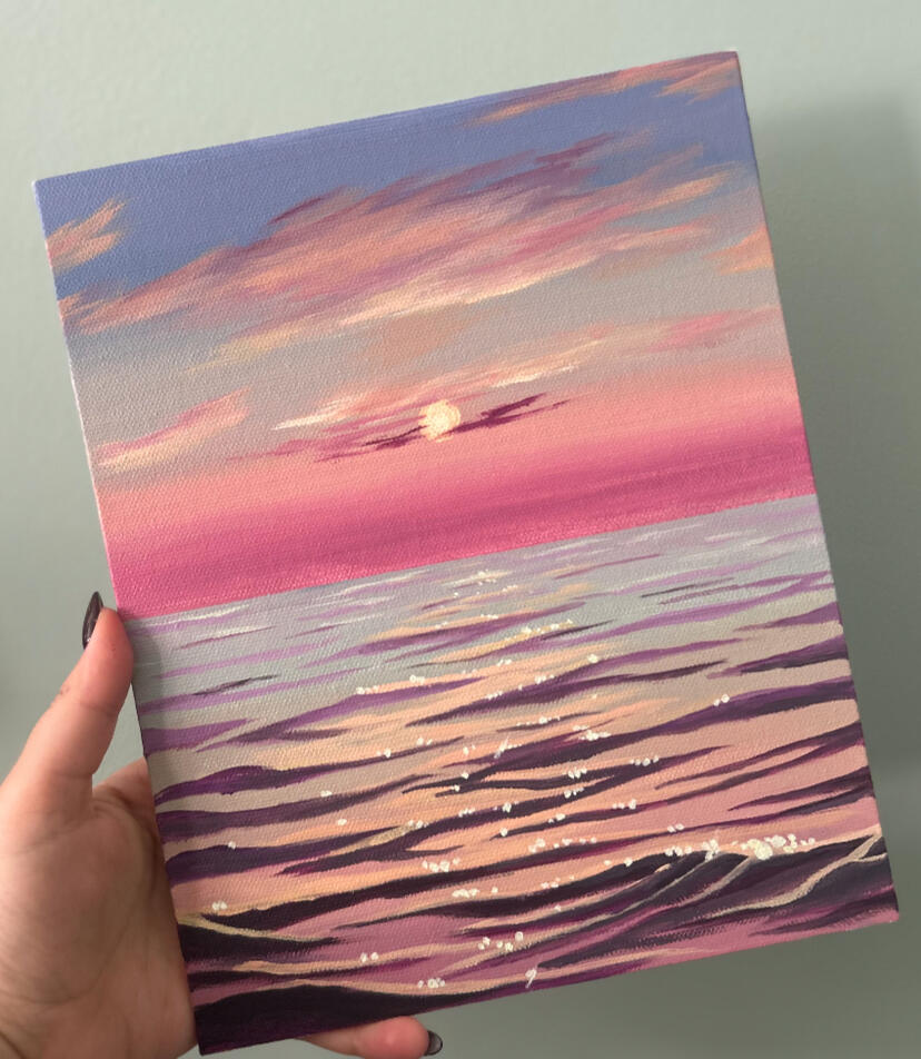 seascape sunset painting held by hand.