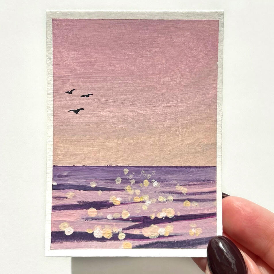 sold pink seascape aceo, showing a pink sea surface with glowing ripples and pink sky with 3 birds flying. painting showed held by hand.